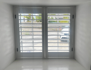 White-finish shutters with classic black hinges in Llanon