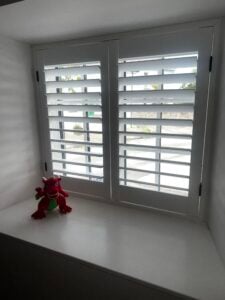 White-finish shutters with classic black hinges in Llanon