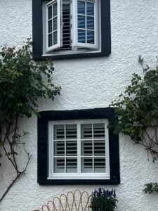 White-finish shutters with classic black hinges in Llanon